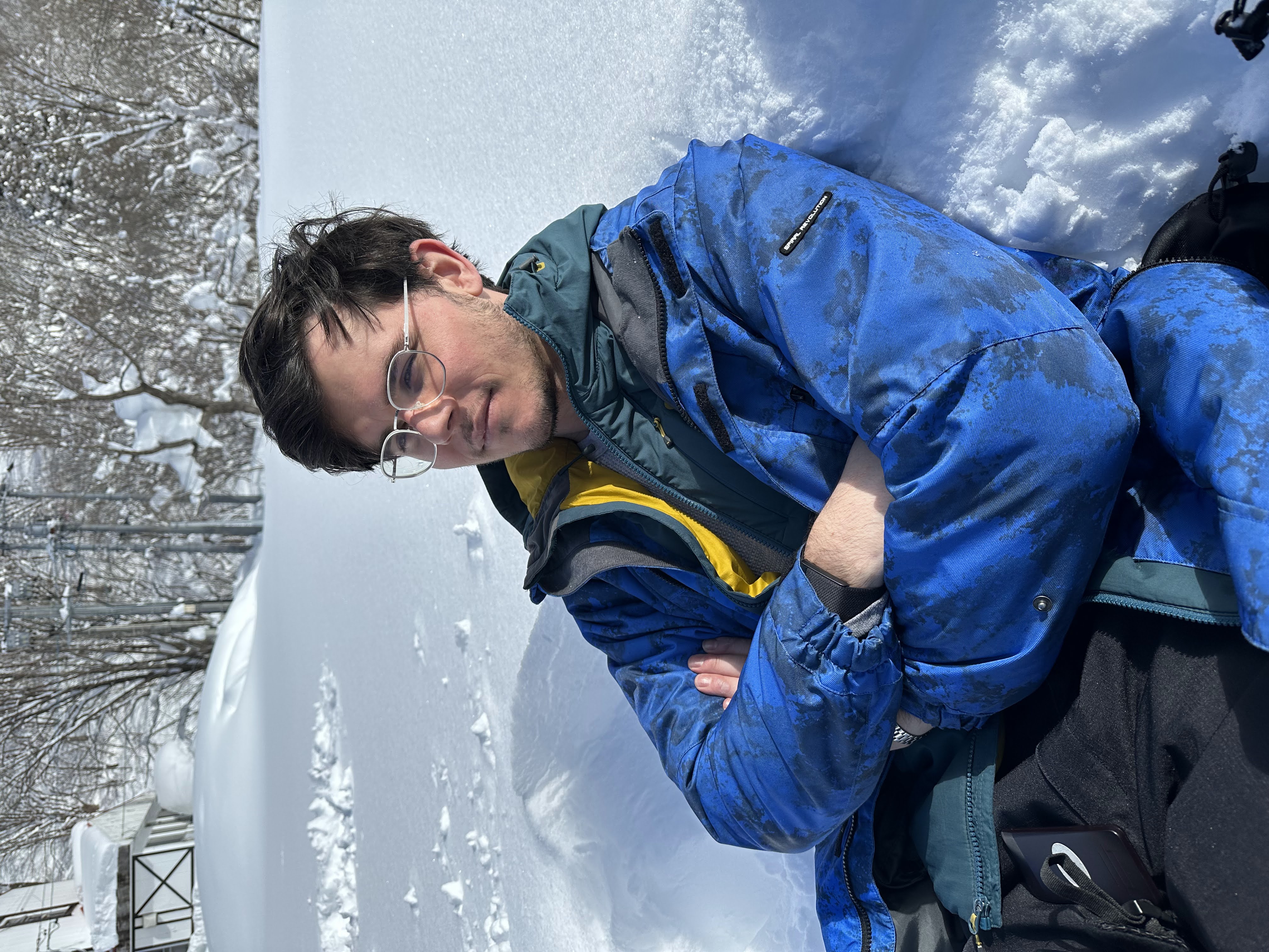 Dano Morrison in a blue jacket, sitting in snow.